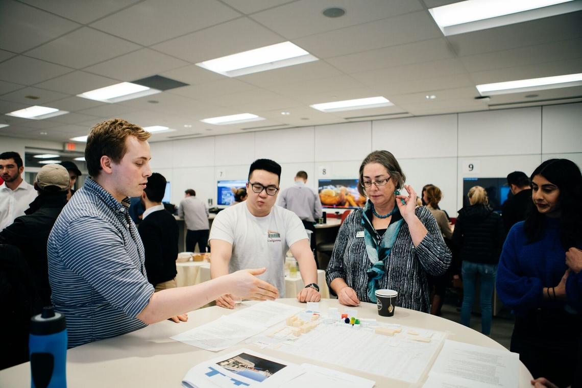 From left: Kevin Fallwell, Aaron Li, Alice de Koning (senior instructor) and Komil Rehill discuss entrepreneurial ecosystems over a scale model of Kensington.