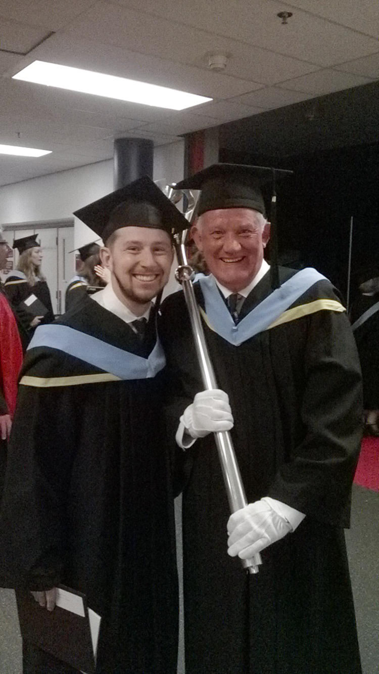 Gavin Peat takes a break from his ceremonial duties to pose with a student.