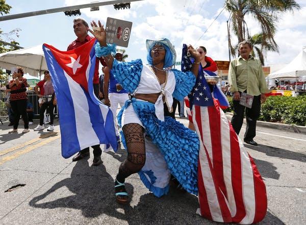 People wave American and Cuban flags as they dance to music at the Calle Ocho Festival,