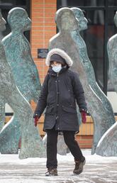 A pedestrian wearing a mask crosses a street in Calgary in November 2020.