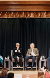 Four people sit together on a stage