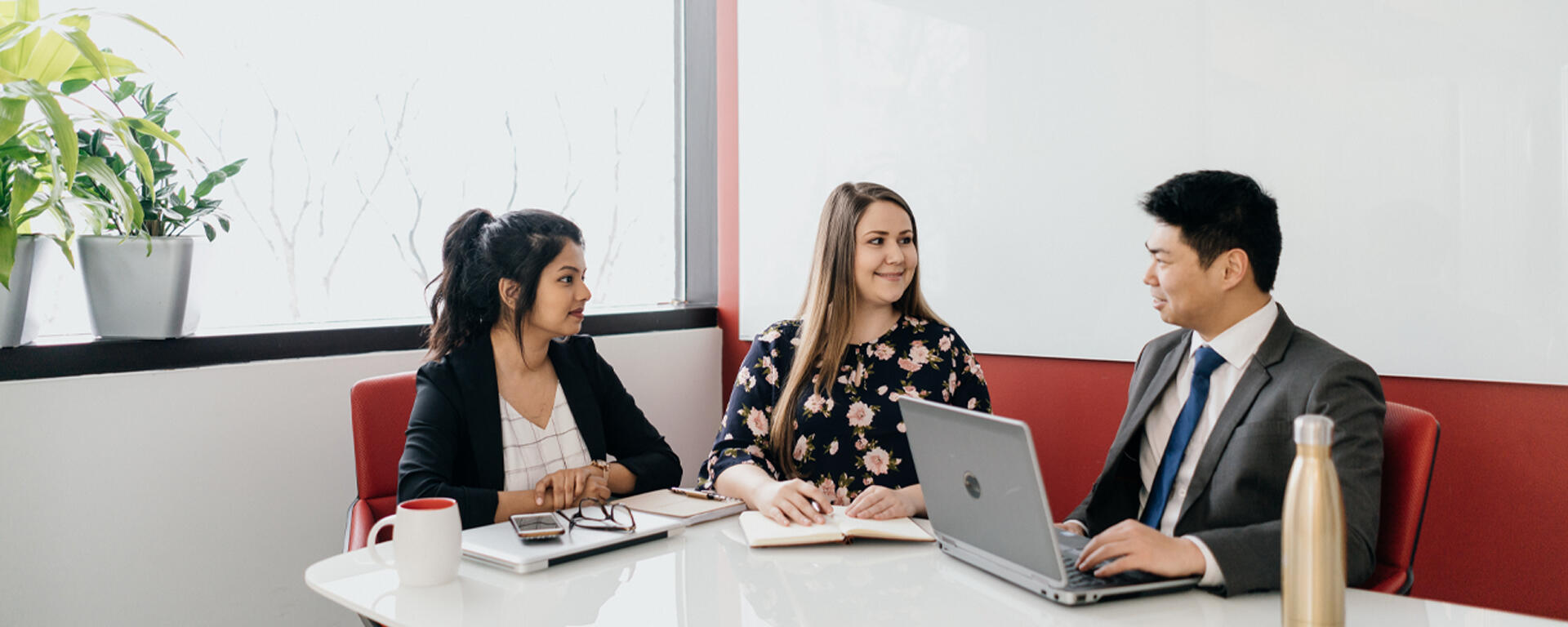 Two students sit with an advisor