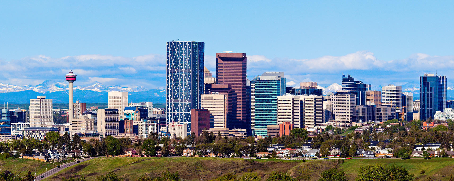 A summer view of the Calgary skyline with the Rockies in the background