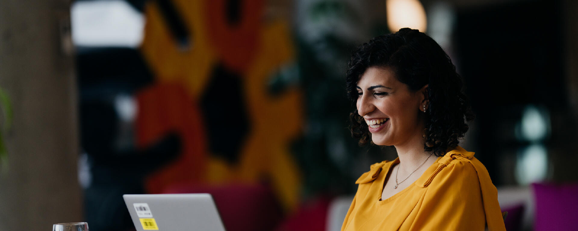 Staff member smiling and working on laptop