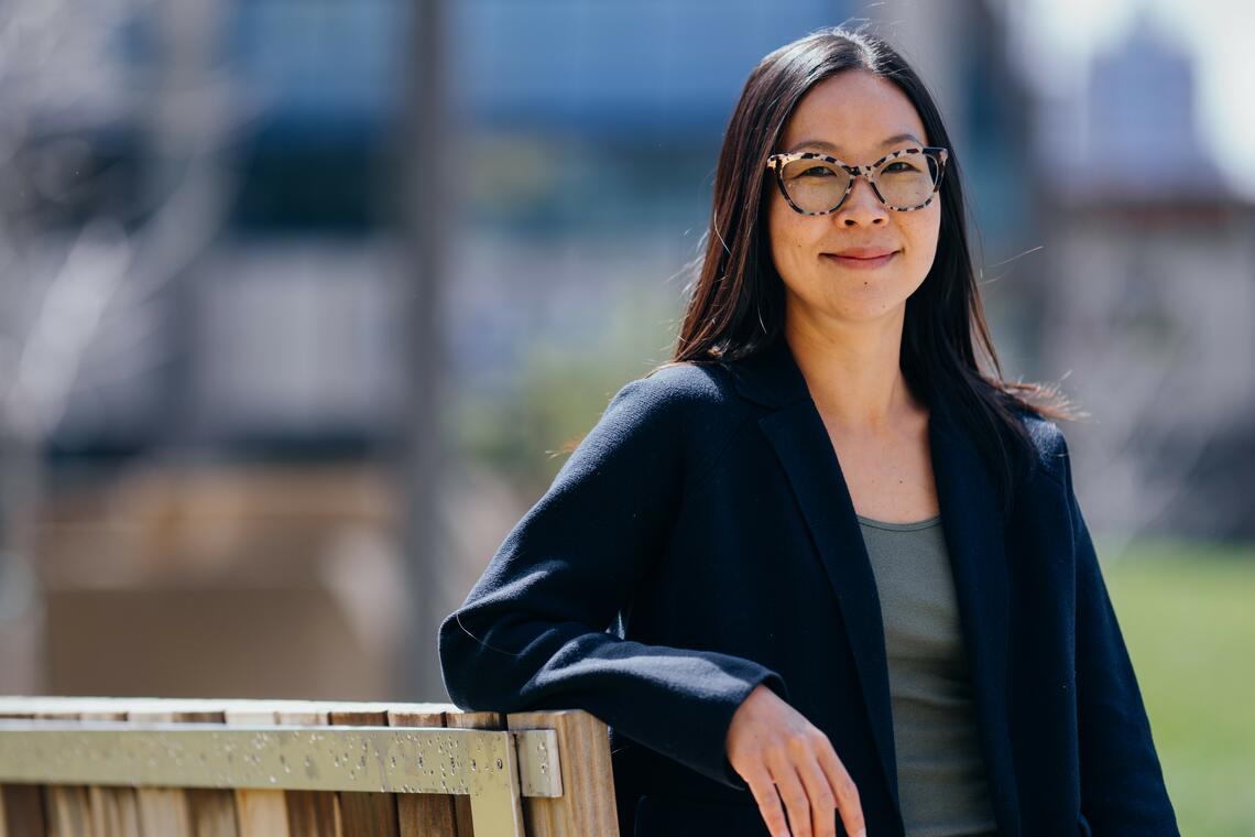 Woman outside leaning on bench