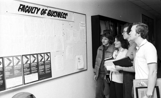 Faculty of Business students checking a bulletin board, October 1977.