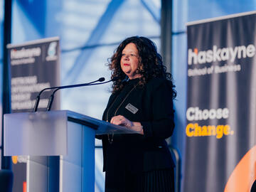 Dean Gina Grandy of the Haskayne School of Business remarks on stage