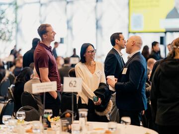 2025 PETRONAS guests laughing and mingling